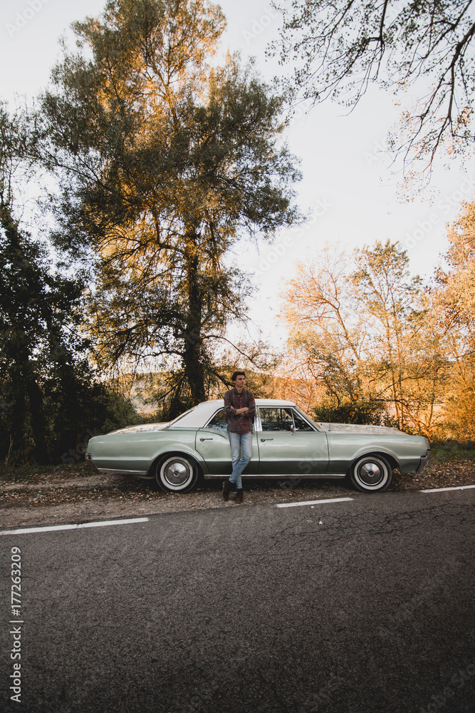 Confident man leaning on car trunk Confident man leaning on car trunk