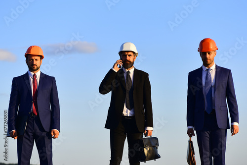 Workers and engineer hold meeting. Architects with serious faces