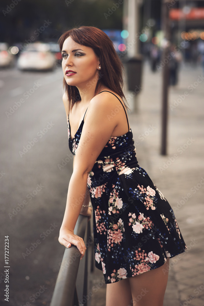 beauty redhead girl in street wearing a flower dress