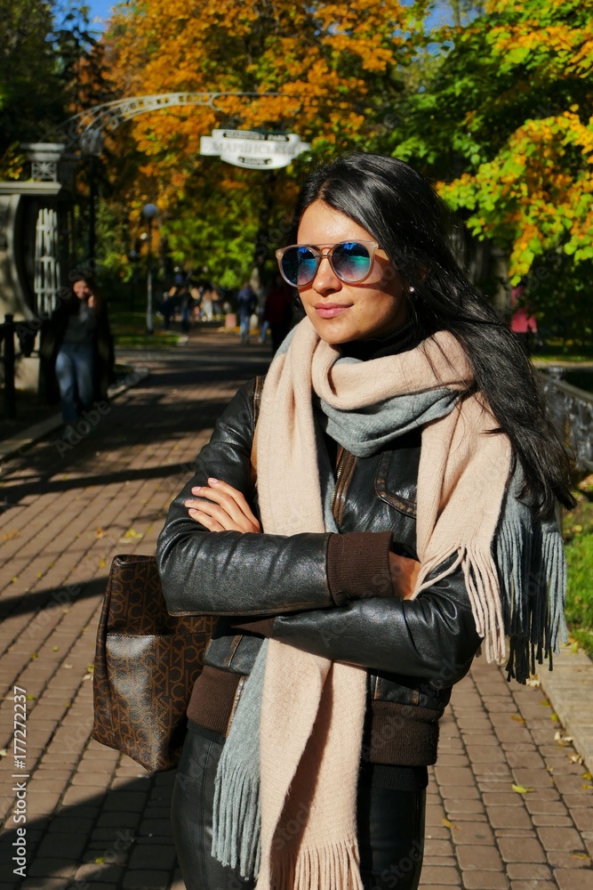 Fototapeta premium Portrait of beautiful young woman in autumn garden. 