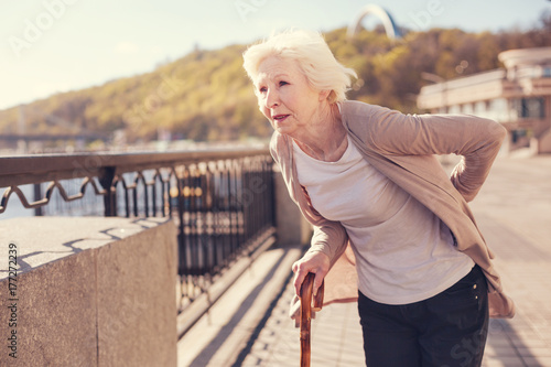 Pleasant senior woman suffering from lower back pain