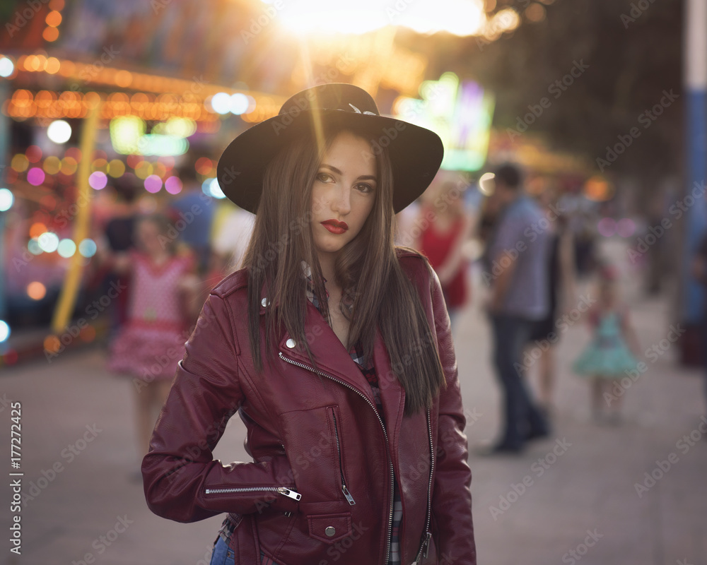 beauty girl with a hat in a fair with many lights beauty girl with a hat in a fair with many lights