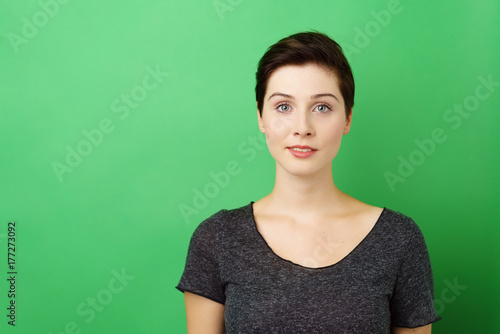 sympathische junge frau vor grünem hintergrund photo