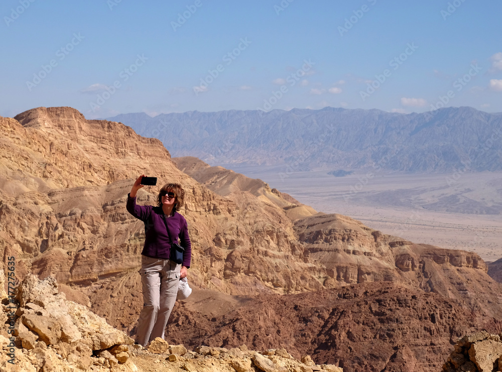 Woman make selfie on scenic hike in Eilat Mountains.