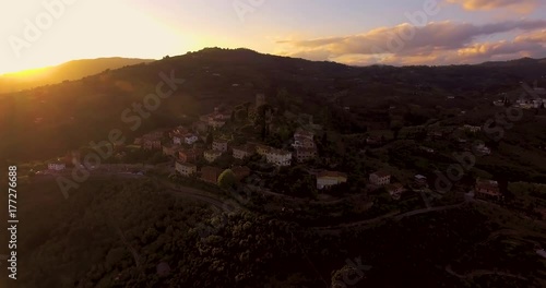 Aerial shot, a small tuscan hamlet on the hill in the sunset light in Italy, 4K photo