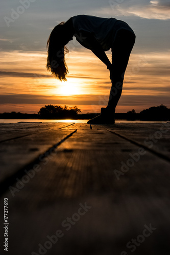 colorful sunset and silhouette of woman on the lake