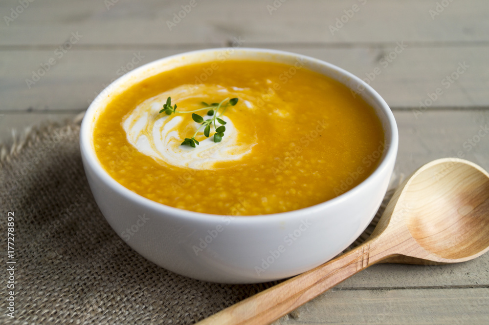 Vegetarian pumpkin soup on a wooden table. Vegetarian pumpkin soup on a wooden table.