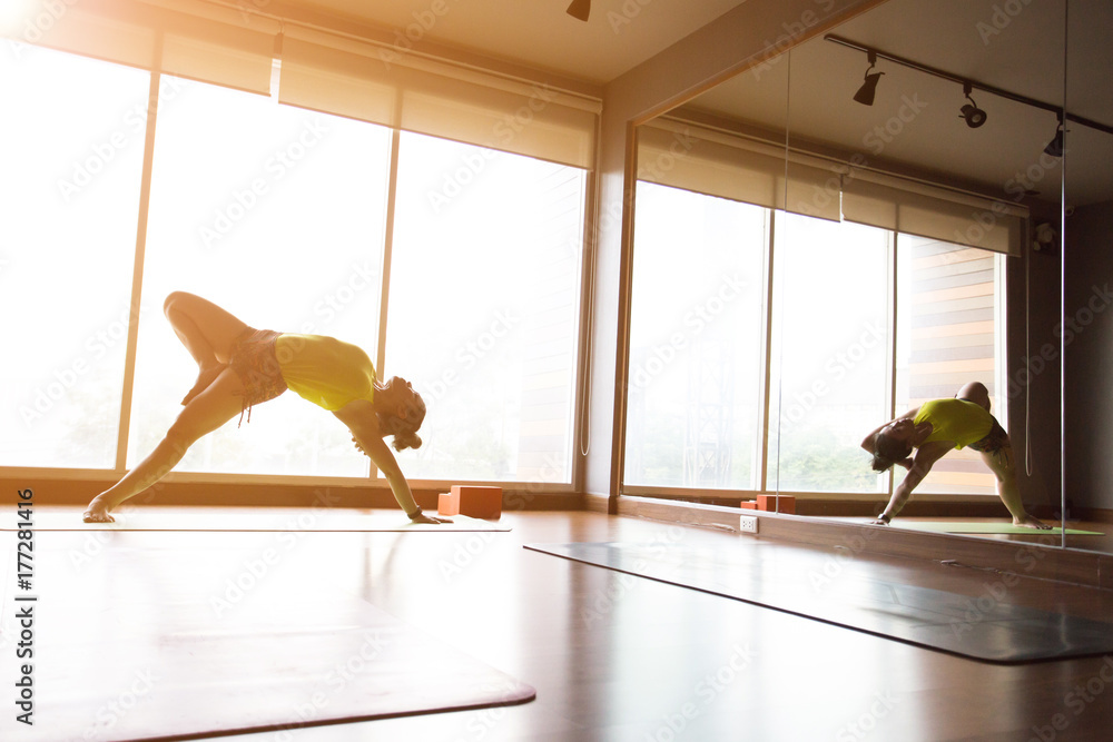 Asian woman doing yoga in a room with sunlight coming through the window. Asian woman doing yoga in a room with sunlight coming through the window.