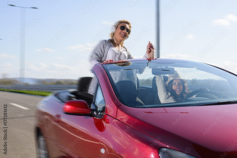 Two beautiful young women driving the car