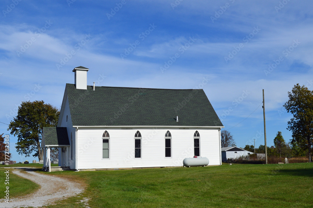 Rural landscape photo of a simple old white church in the country
