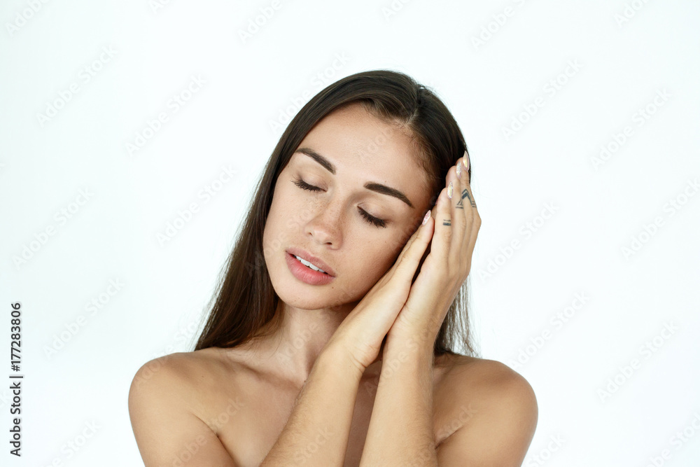 Dreamy woman touches her face tender standing on white background Dreamy woman touches her face tender standing on white background