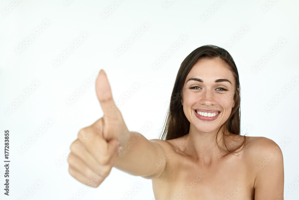 Lucky young woman raises her thumb up standing on white background Lucky young woman raises her thumb up standing on white background