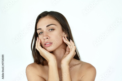 Dreamy woman touches her face tender standing on white background