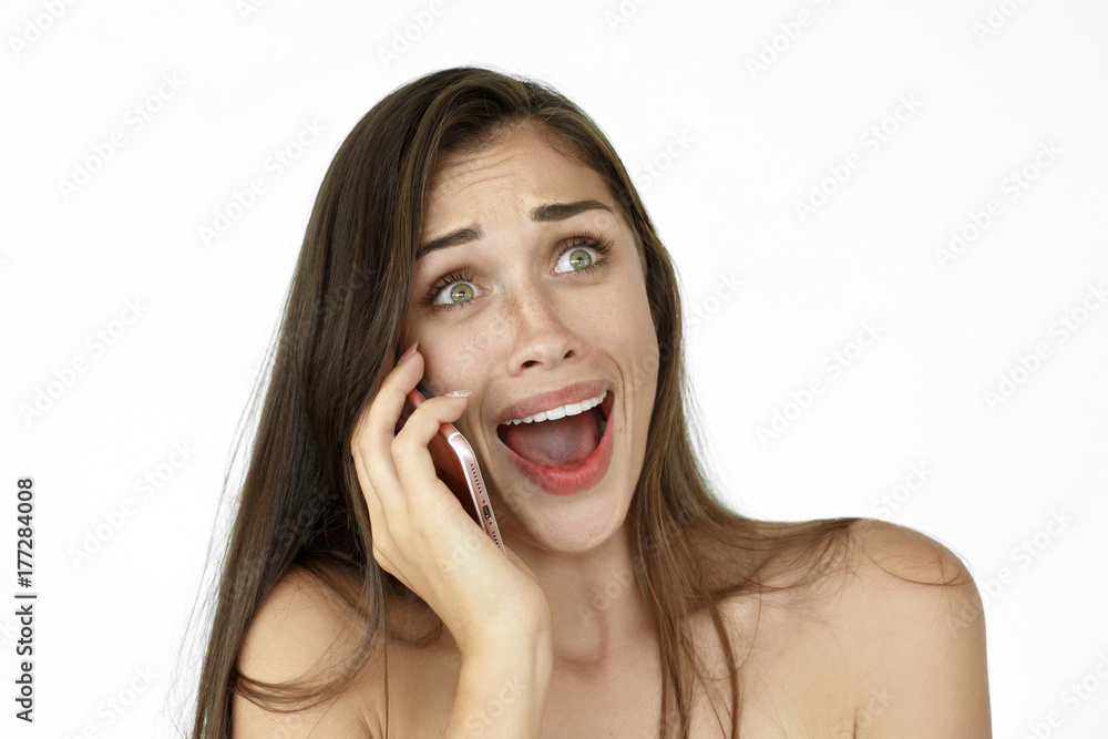 Fototapeta premium Pretty laughing woman talks on the phone standing on white background
