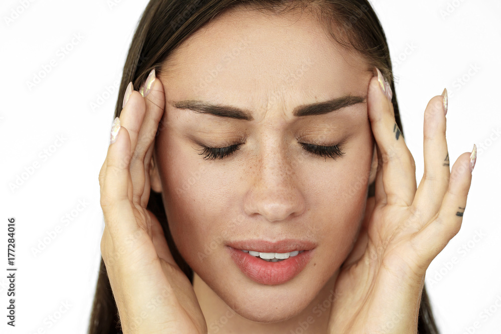 Woman holds fingers on her temples showing headache Woman holds fingers on her temples showing headache