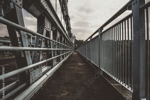 Fototapeta Naklejka Na Ścianę i Meble -  a architecture shot of a bridge walkway with railings each side .