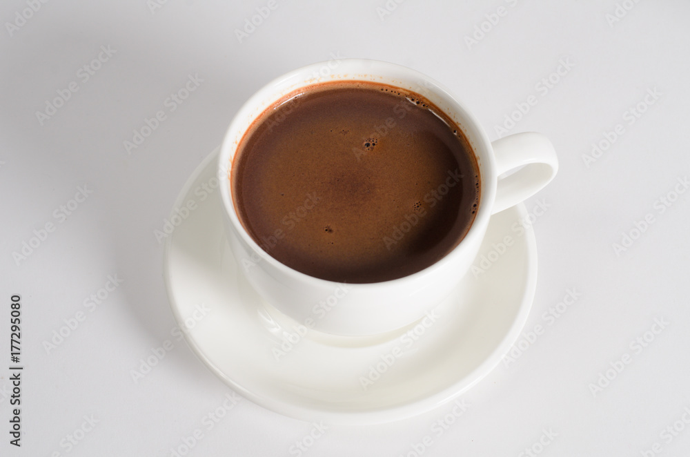 A cup of hot chocolate with cocoa powder on white background A cup of hot chocolate with cocoa powder on white background
