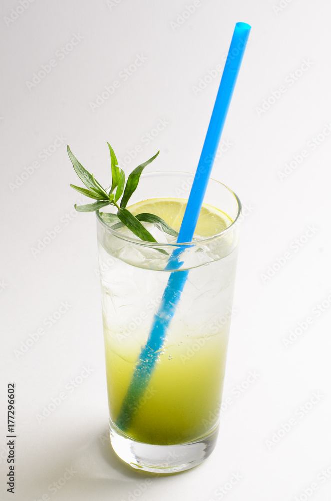 Tarragon lemonade with lemon in a glass on white background Tarragon lemonade with lemon in a glass on white background