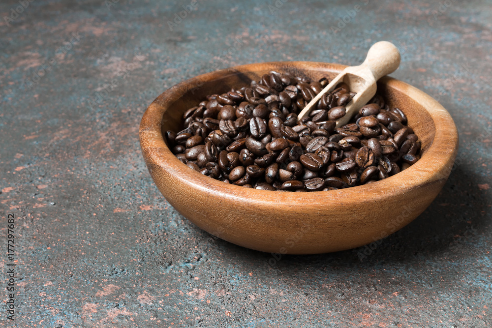Coffee beans in a wooden bowl on a dark background with copy space in a minimalist style Coffee beans in a wooden bowl on a dark background with copy space in a minimalist style