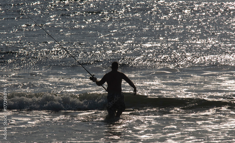 Newbury: A surf caster wades into the ocean on Plum Island early Saturday morning. Jim Vaiknoras/staff photo