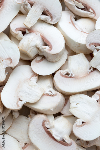 Fresh white champignons (mushrooms), sliced, uncooked, background, full