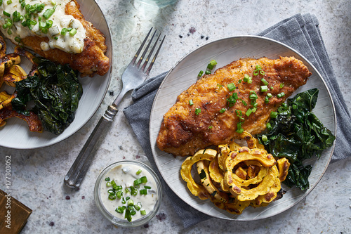 panfried catfish dinner with squash and spinach in flat lay compositon