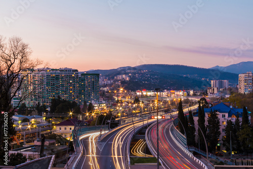Beautiful aerial view of city, mountains and highway "Doubler of Kurortnyy Prospekt" after sunset, Sochi, Russia