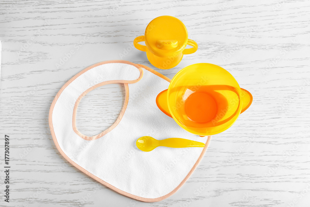 Set with bright baby dishware on table Set with bright baby dishware on table