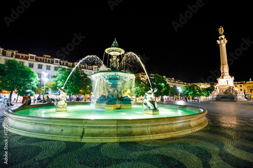 Lisbon downtown, Baixa District. Urban scene by night. Spectacular baroque fountain and statue of Dom Pedro IV in Praca Dom Pedro IV or Rossio Square in Lisbon, Portugal, Europe.