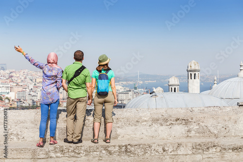 Photography Group of multiracial happy Friends sitting near the mosque and enjoying view of