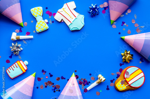 Cook gingerbread cookies with ticker tape for baby shower on blue colorful background top view mockup