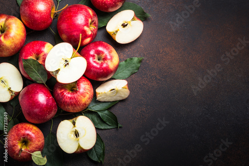 Red apples with leaves on the table.