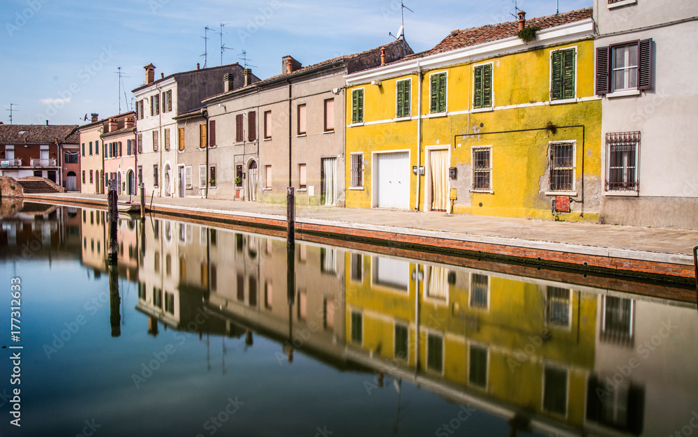 houses and reflections over a canal in Italy