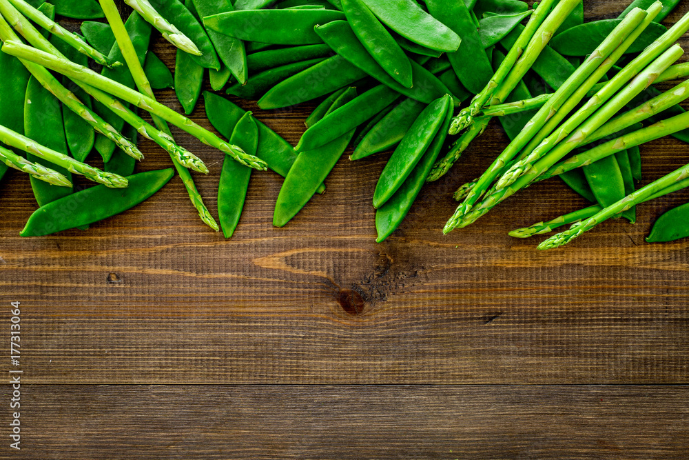 Fresh pea pods on dark wooden background top view copyspace