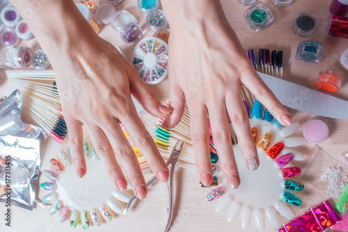 Nail art concept. Woman making decoration on the nails on white table
