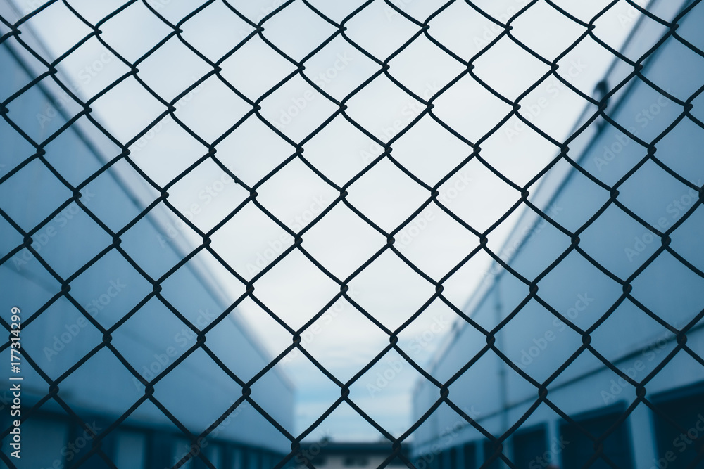 Chain-link fence in front of industrial warehouse Chain-link fence in front of industrial warehouse