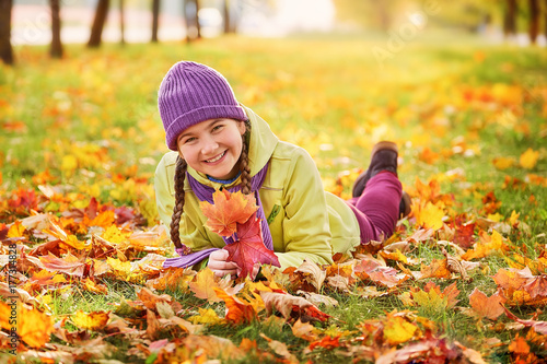 smiling teenage girl relaxing in autumn Park yellow.yellow.autumn portrait of baby in maple leaf
