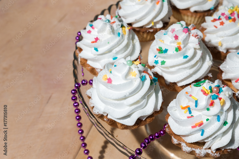 Cakes with white cream and colored powder on a glass stand Cakes with white cream and colored powder on a glass stand