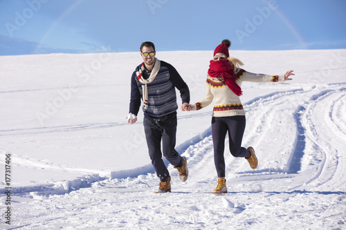 Happy couple playful together during winter holidays vacation outside in snow park