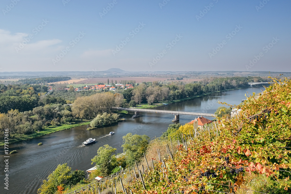 Obraz premium Two ships floating near bridge over european river Labe when viewed from lookout in Melnik city in autumnal czech landscape