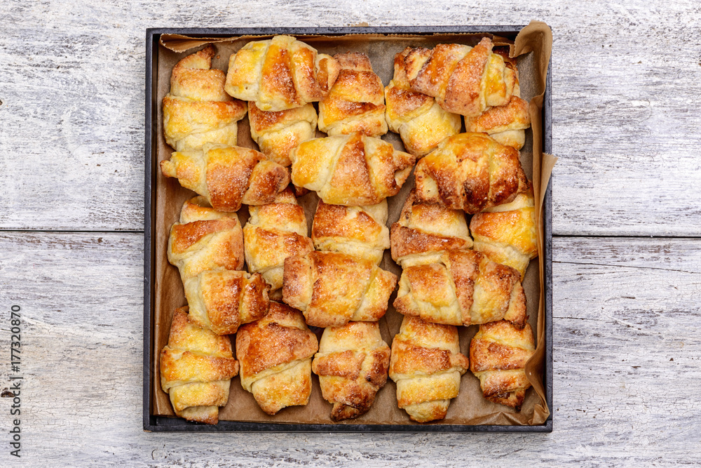 handmade croissants on a backing tray on a wooden background handmade croissants on a backing tray on a wooden background