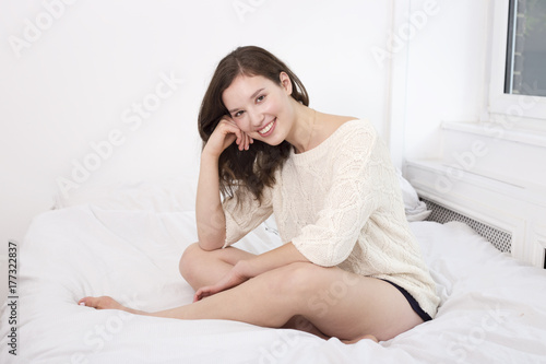 happy woman sitting on her bed