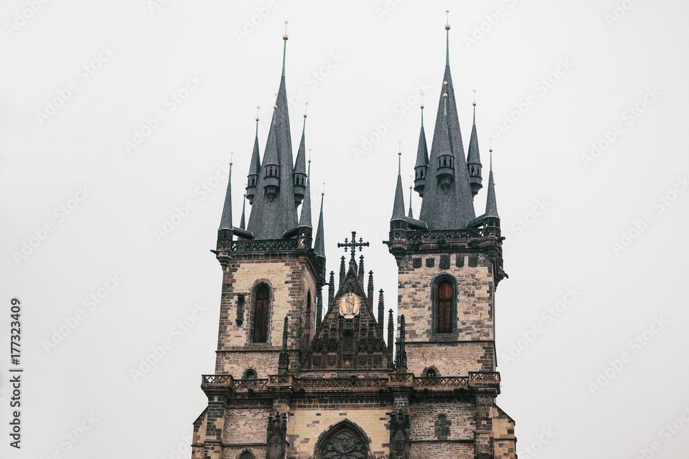 Beautiful old temple on the main square in Prague with black roof against gray sky background