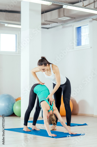 teacher helping with yoga pose indoors