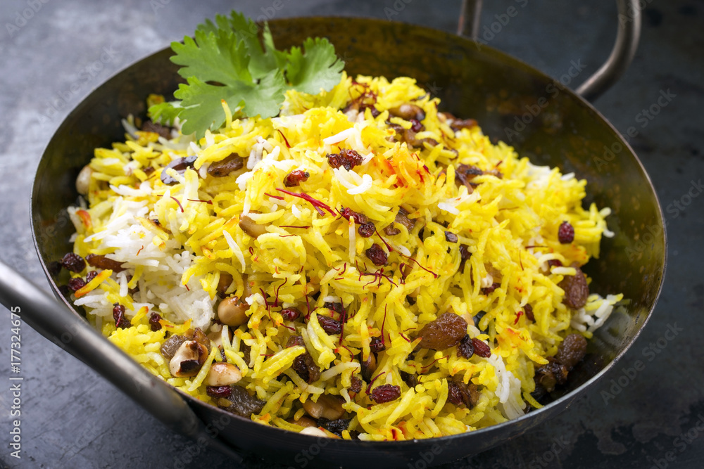 Indian vegetarian biryani with nuts and raisins as close-up in a korai Indian vegetarian biryani with nuts and raisins as close-up in a korai
