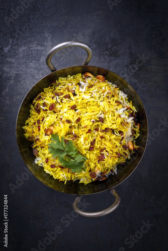 Indian vegetarian biryani with nuts and raisins as close-up in a korai photo