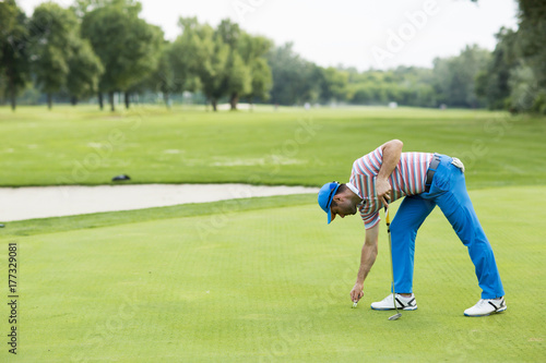 Man playing golf on a sunny day on a beautiful golf course