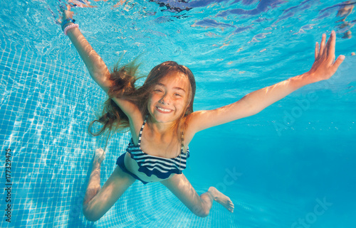 Girl swimming and diving in blue pool with fun