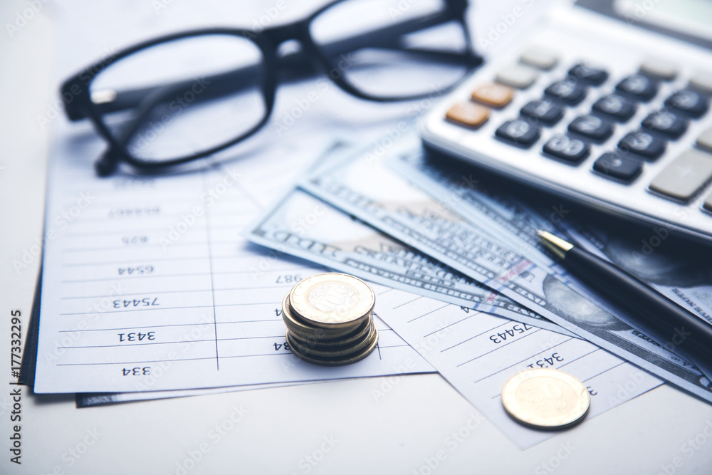 money, calculator and glasses on the document money, calculator and glasses on the document
