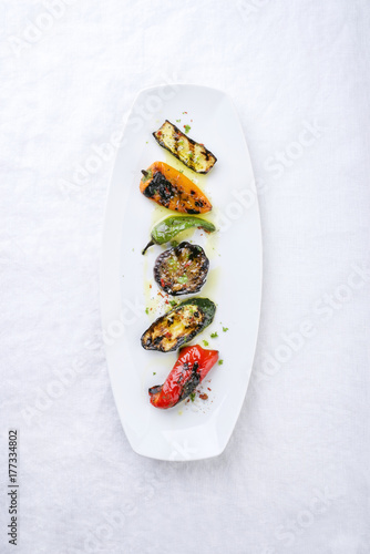 Traditional Italian barbecue antipasti creative decorated as top view on a white plate photo